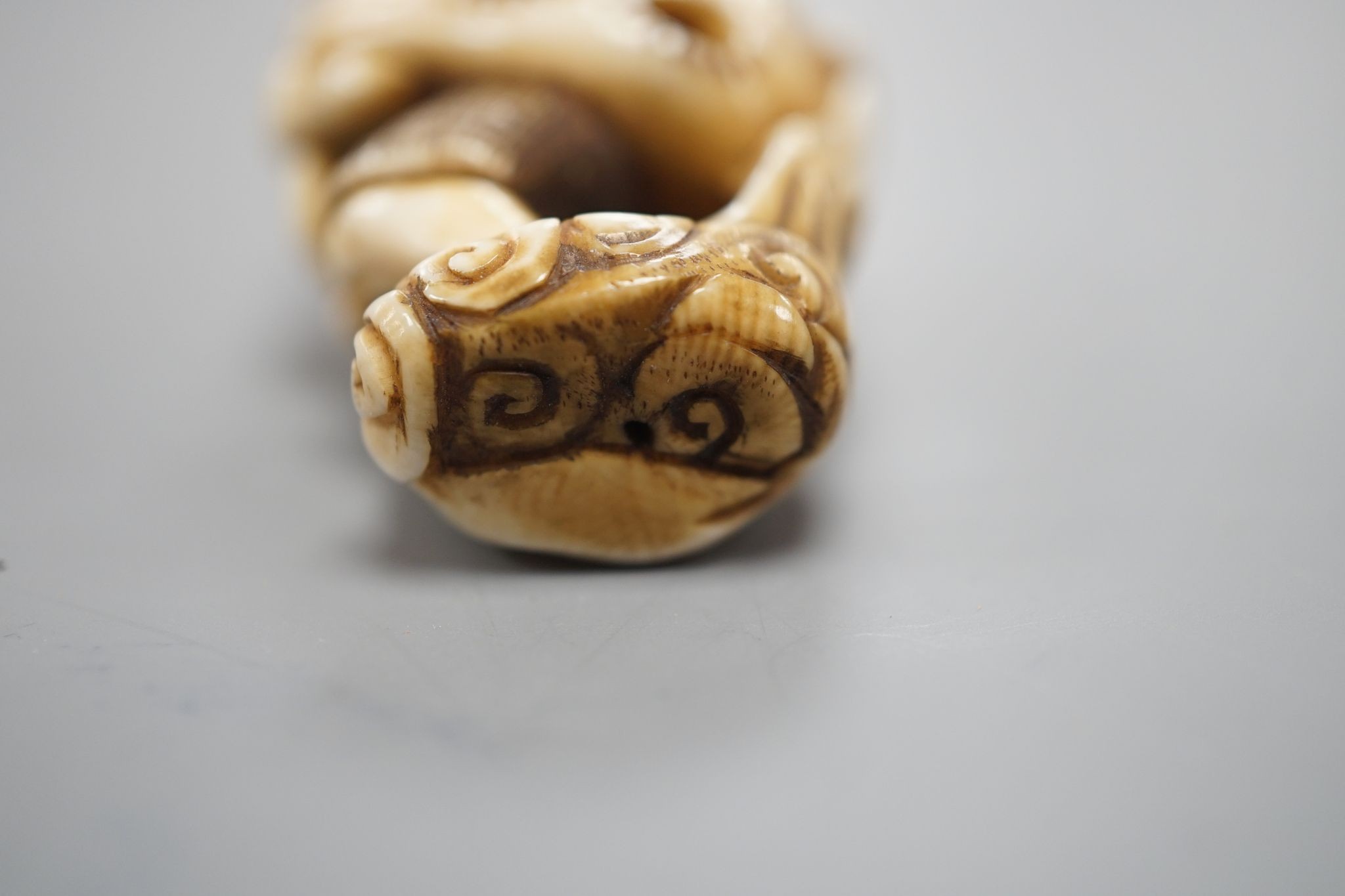 A Japanese ivory netsuke of oni, Meiji period, 4 cms high.